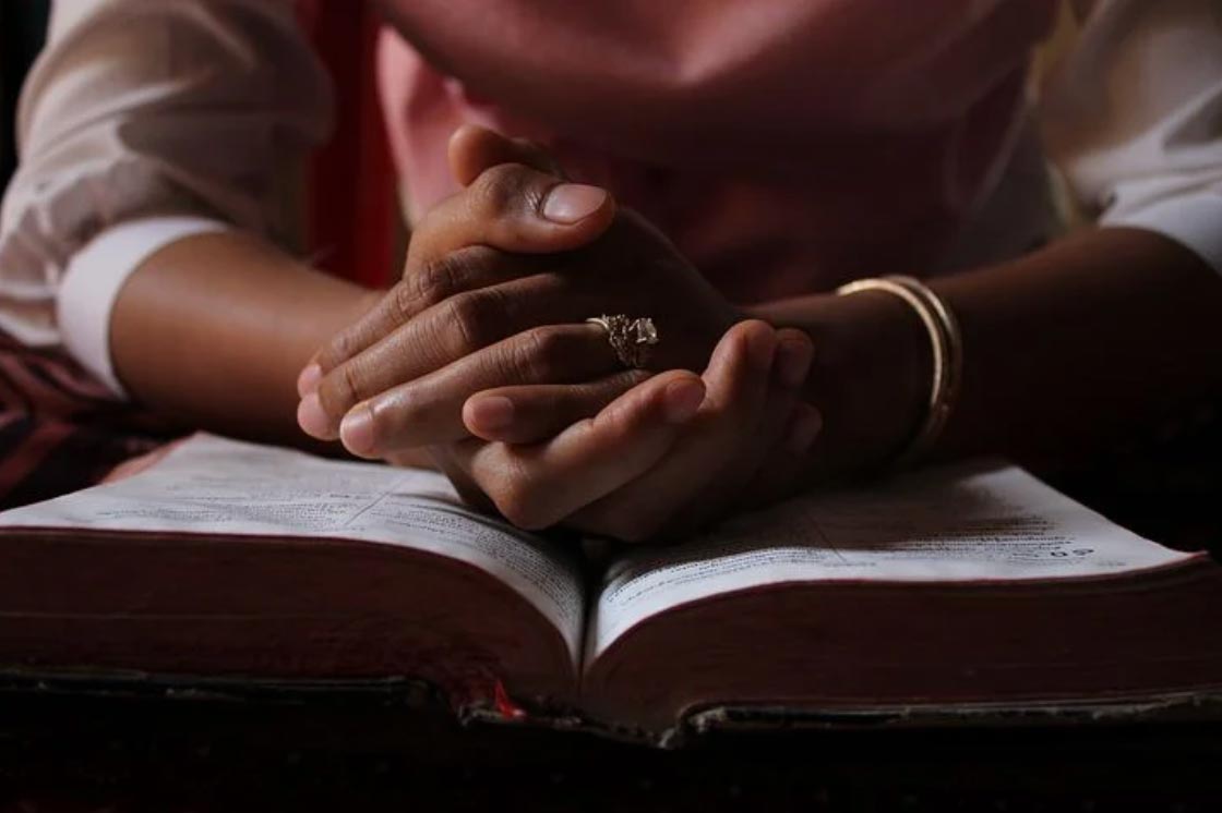 PRAYING HANDS ON BIBLE